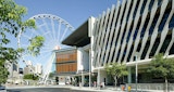 Alternative view of ABC Headquarters building. Building side profile with view to Ferris wheel behind. Sunny day with people walking around and city view in far distance.