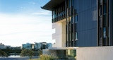 Building exterior facing brisbane river and city behind. Late afternoon sun shines on black and white exterior of Cutting Edge Post Production facility building, architecture by KIRK Studio.