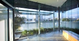 Office view inside Cutting Edge Postproduction facility building. Architecture design by KIRK Studio. Empty room with three glass walls overlooking Brisbane river and city view at sunset.