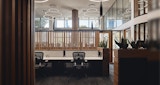 Timber batten separating screen and row of communal desk seating. Planter boxes, circular overhead pendant lighting.