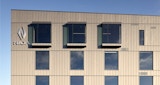 Side profile view of top three levels of NIOA completed office building. evenly spaced windows and vertical metal cladding and NIOA logo on side of building.