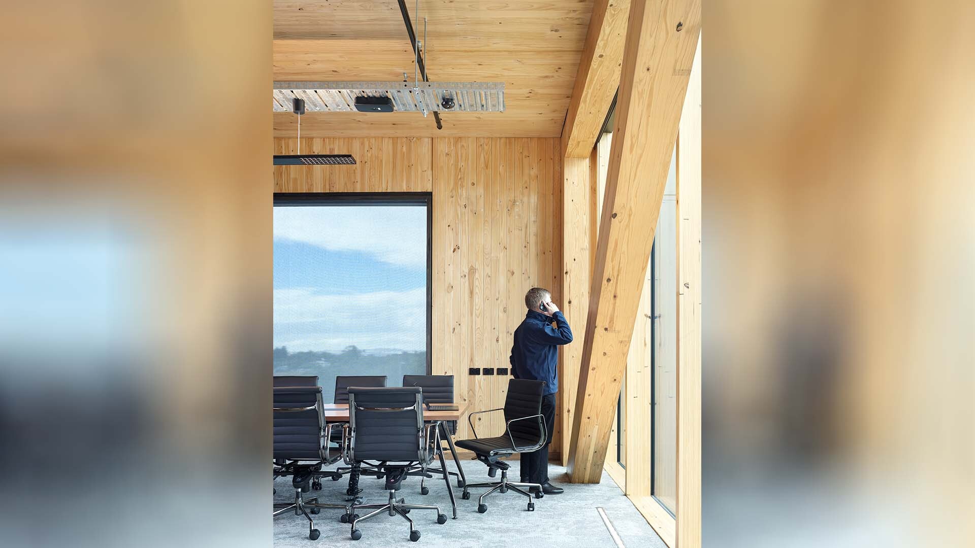 Office space with man on phone inside the NIOA Timber tower office expansion - Architecture by KIRK Studio. Professional architectural photography by Scott Burrows.