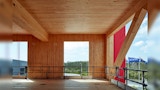 room interior of mass engineered timber building under construction. window cavities open to the outdoors and steel protection railing.