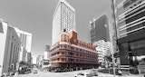 Five level historical brick building in color with busy city street and high-rises in black and white.