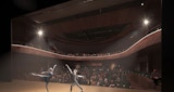 Concept Render - View from stage inside Garden International performing arts center of a male and female ballet dancer preforming in front of a large audience. - Architecture by KIRK Studio.