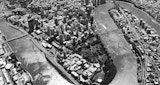 Black and white aerial image of the Brisbane river and surrounding cityscape.